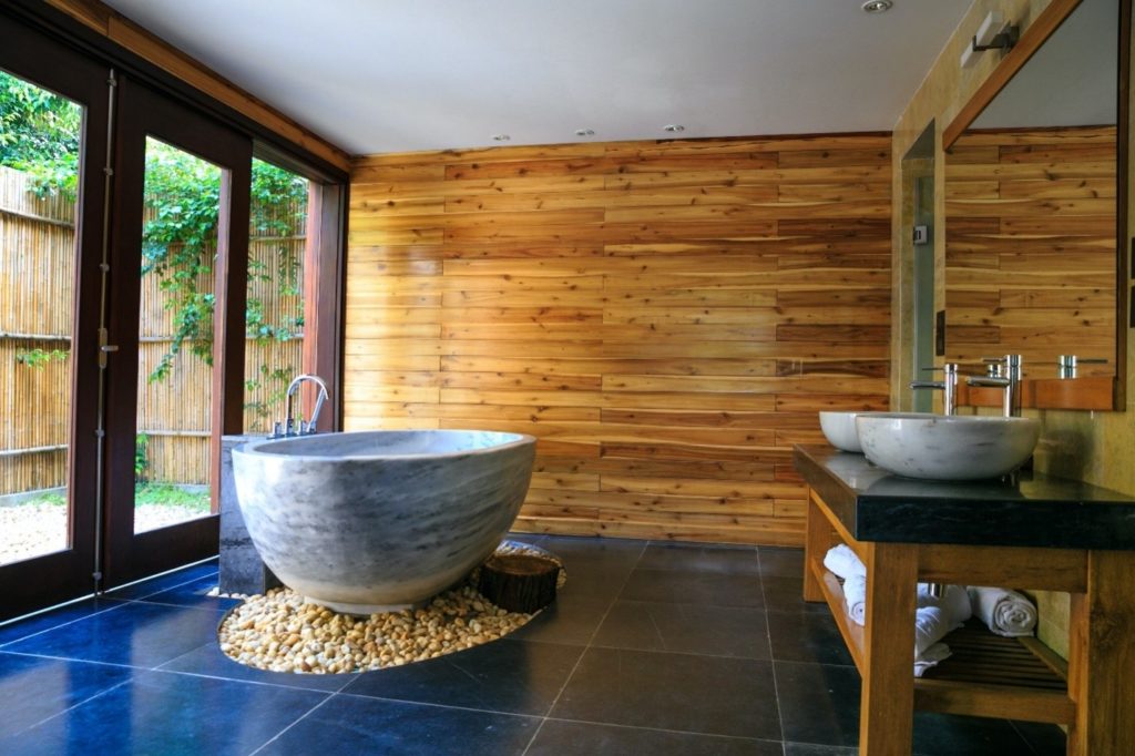 : A modern bathroom design using stone, wood and tile has a spa-like feel